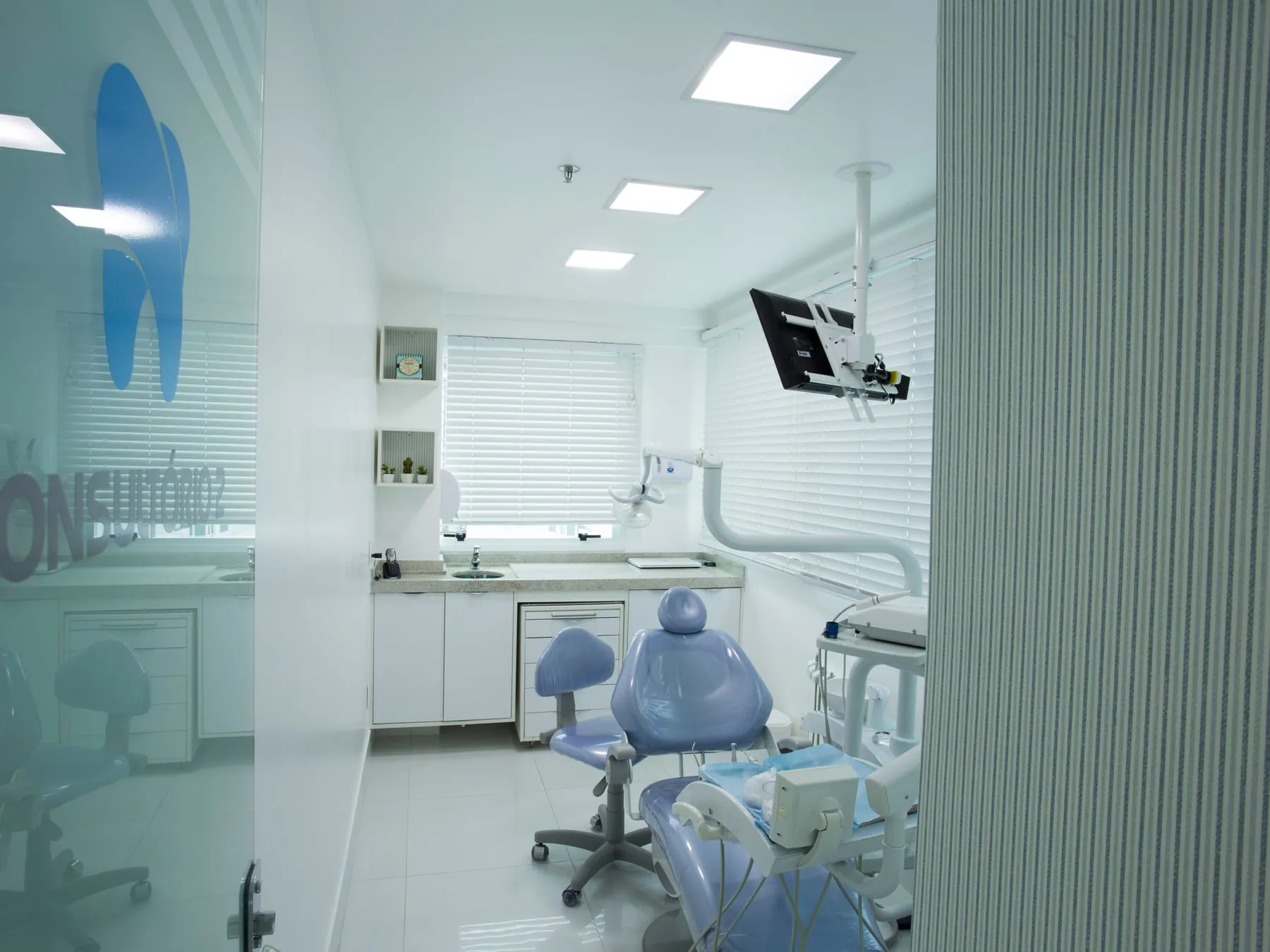 Consultório Orto Implan com cadeira azul e identidade visual